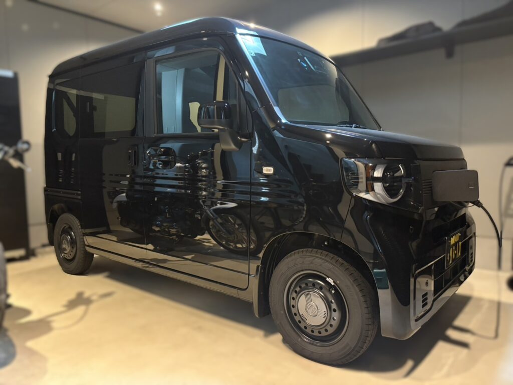 黒ナンバー仕様のN-VAN e: ガレージで充電中のEV車両
