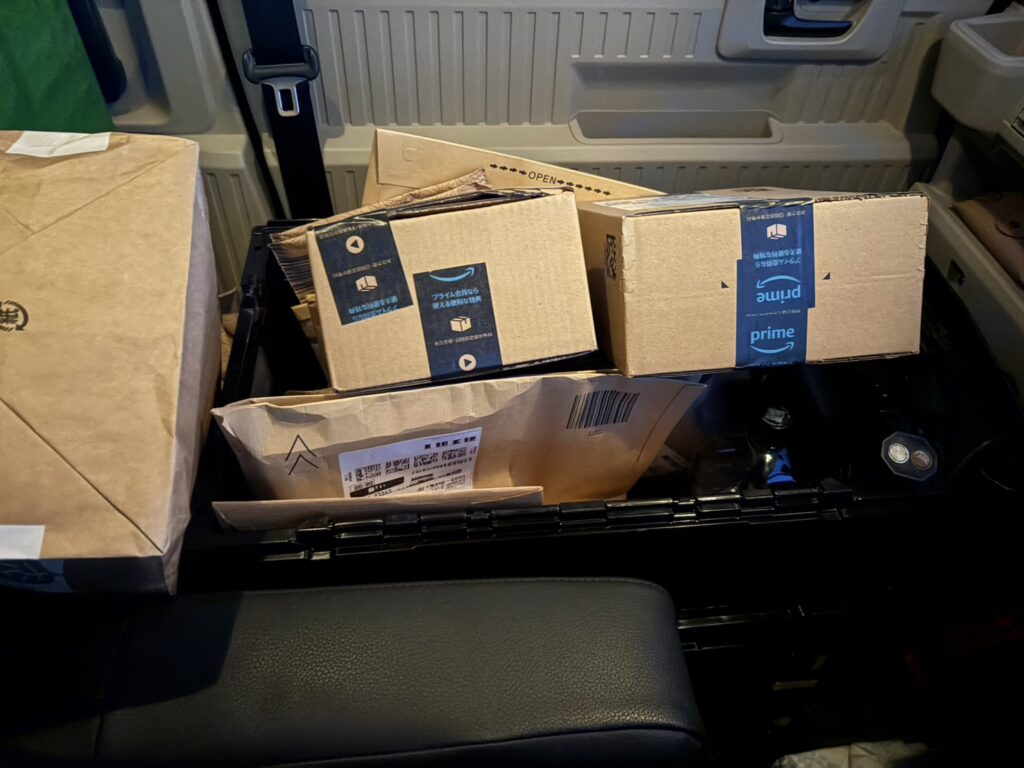 N-VAN e:の助手席横に並べられたAmazonの荷物。封筒や段ボールを効率よく積み込んだ様子