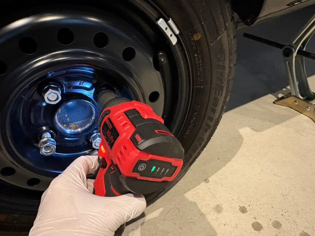 インパクトレンチでホイールナットを緩める作業