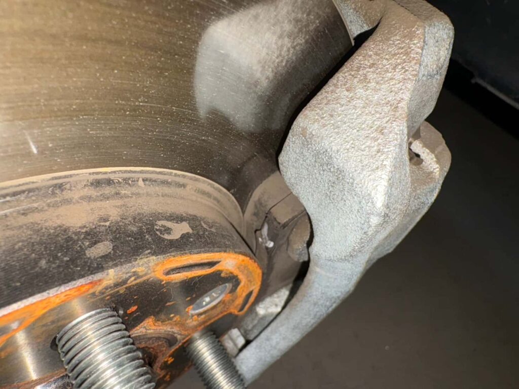 ノギスでブレーキパッド残量を測定している様子